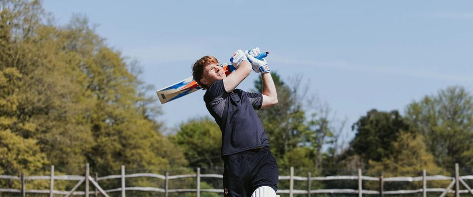 Cricketer playing a lofted shot with a Gray-Nicolls bat